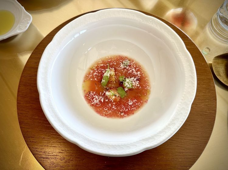 Zuppa di susine: susine cotte confit, come se fossero un pomodoro (con olio, odori, sale e zucchero), basilico, sugo di cottura delle susine, acqua di pomodoro messa sotto vaso e recuperata da Podere Francesco (progetto Frutti Audaci) condita con agrumi in infusione e aceto di sambuco, a formare una sorta di brodo freddo, Parmigiano 24 mesi grattugiato, per il tocco umami