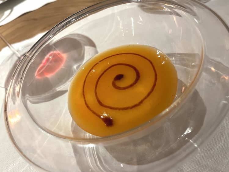 Un lavoro attorno al caco con marrons glacés, panna montata, crema di cachi alla vaniglia e una spirale di genziana in cima. Chiusura speciale