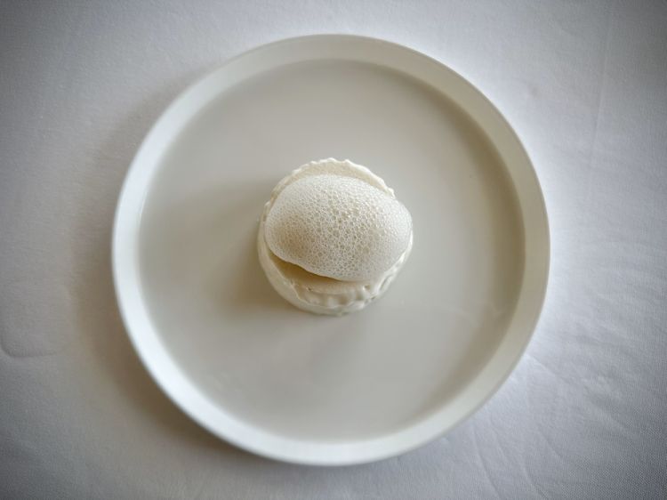 Gelato di mandorla, mandorle, caffè e mirtilli: un dolce in bianco, quello firmato quest’anno da Mattia Casabianca. Dominano la freschezza e i toni di caffè, racchiuso nel ripieno, custodito gelosamente dal mantello bianco delle mandorle in varie consistenze
