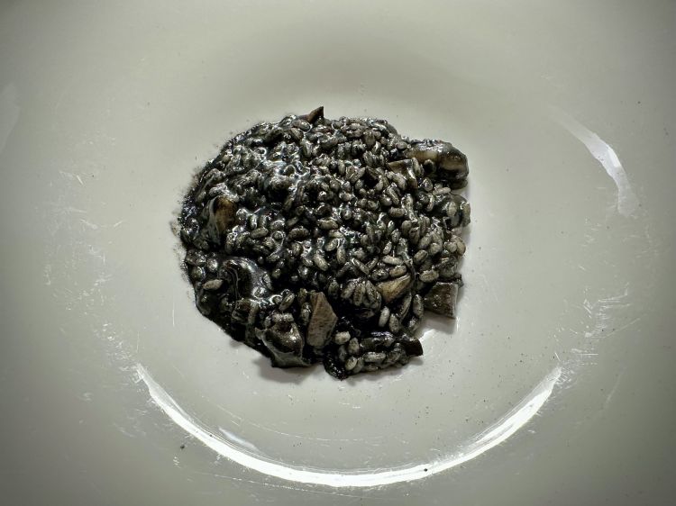 Risotto con le seppie di nassa e il loro inchiostro. Per questa preparazione, le seppie devono essere freschissime, poiché viene usato tutto, anche il fegato. Il riso è un Vialone nano di Ostiglia (Mantova), paese d’origine della mamma di Maria Grazia e Pierluigi, che hanno deciso di recuperare la ricetta originale, che prevedeva proprio questo tipo di cereale. Il piatto è un capolavoro di equilibrio, sia nella sapidità, sia nell’uso del nero di seppia
