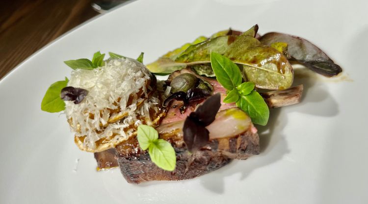 Non mancano, seppur contenute, le proteine animali: l'Agnello alla parmigiana è prima marinato in un'estrazione di jus profumato alla parmigiana e poi arrostito. Sopra all'agnello, c'è un sandwich di melanzana con cremoso di parmigiano, una selezione di basilici e un jus profumato alla parmigiana. Irresistibile nella familiarità e avvolgenza di aromi e sapori