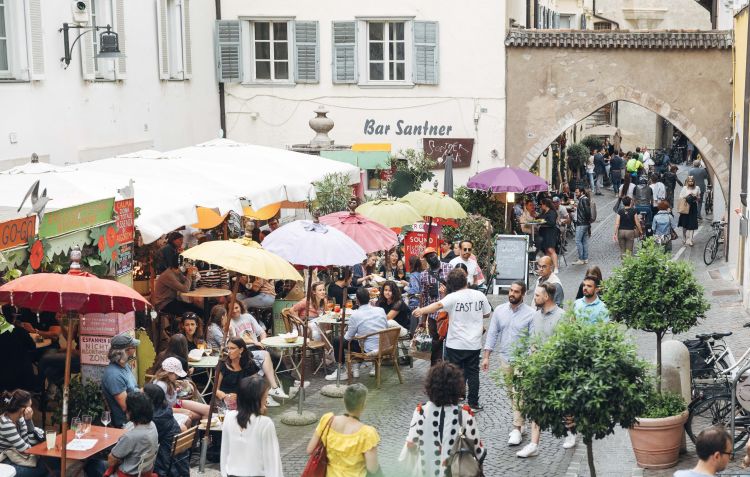 All'ora dell'aperitivo i locali si riempieno di giovani e turisti per un bicchiere di kerner o lagrein o una fresca birra artigianale
