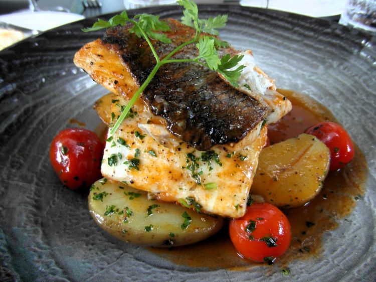 Il Branzino con patate e pomodori su un fondo di crostacei servito al Thaler Arome