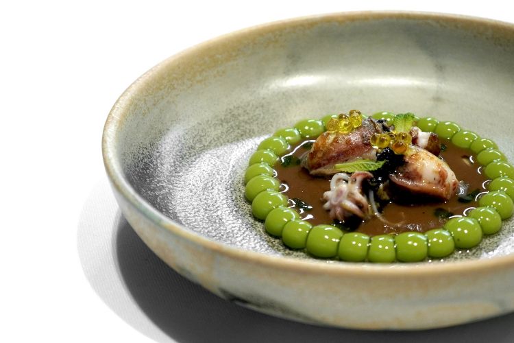 Squid with multispheric Catalan peas: it’s all seasoned with a sauce of botifarra negra, a typical Catalan sausage, made with part of the boiled blood of a pig. The "fake peas" are made with a cream of spherified peas with the multi-sphere technique, that is to say a series of spherifications, stabilised with a gel of glutamate (see the famous Tatin de foie-gras y maíz multiesférico, here)