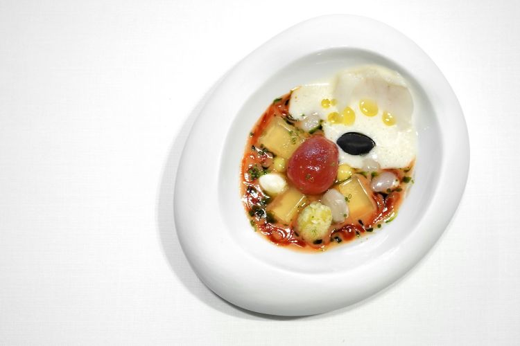 Cod "empedrat" with almonds. Another marvellous, perfect dish. It’s based on empedrat, a typical Catalan dish, a sort of cold salad with white beans, salted cod, hardboiled eggs, pepper, onion, olives and tomato. Here we have the almonds cooked in Ocoo (we saw it in the previous photo), which recall the texture of the white beans, which are served on the side, in the shape of water of white beans which you can sip while eating, see the photo below. And then gel of tomato, fresh tomatoes, seeds of pimiento de Padrón (an extraordinary green and sweet small pepper)...