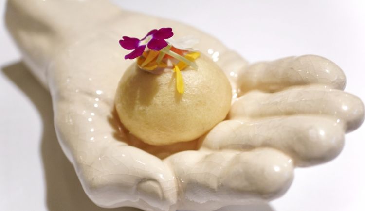S'inizia. Il primo boccone è un a piccola Brioche con fegato di merluzzo, uova di trota e yuzu (un piatto del 2019). S'accompagna con un Elderini (un Martini ai fiori di sambuco) con schiuma e zest di limone e sale alla paprika (2020)