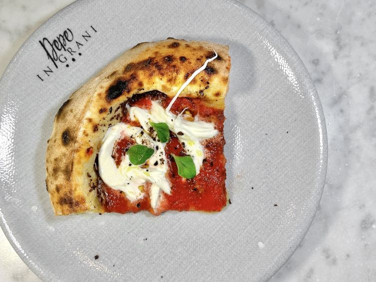 Vulcanica
In tre lavorazioni: in forno con paté di olive caiazzane, a metà cottura viene aggiunta la passata di pomodoro lungo dell’agro sarnese, alla fine - a freddo - treccia di mozzarella di bufala sfilacciata a mano, cappero disidratato e origano fresco